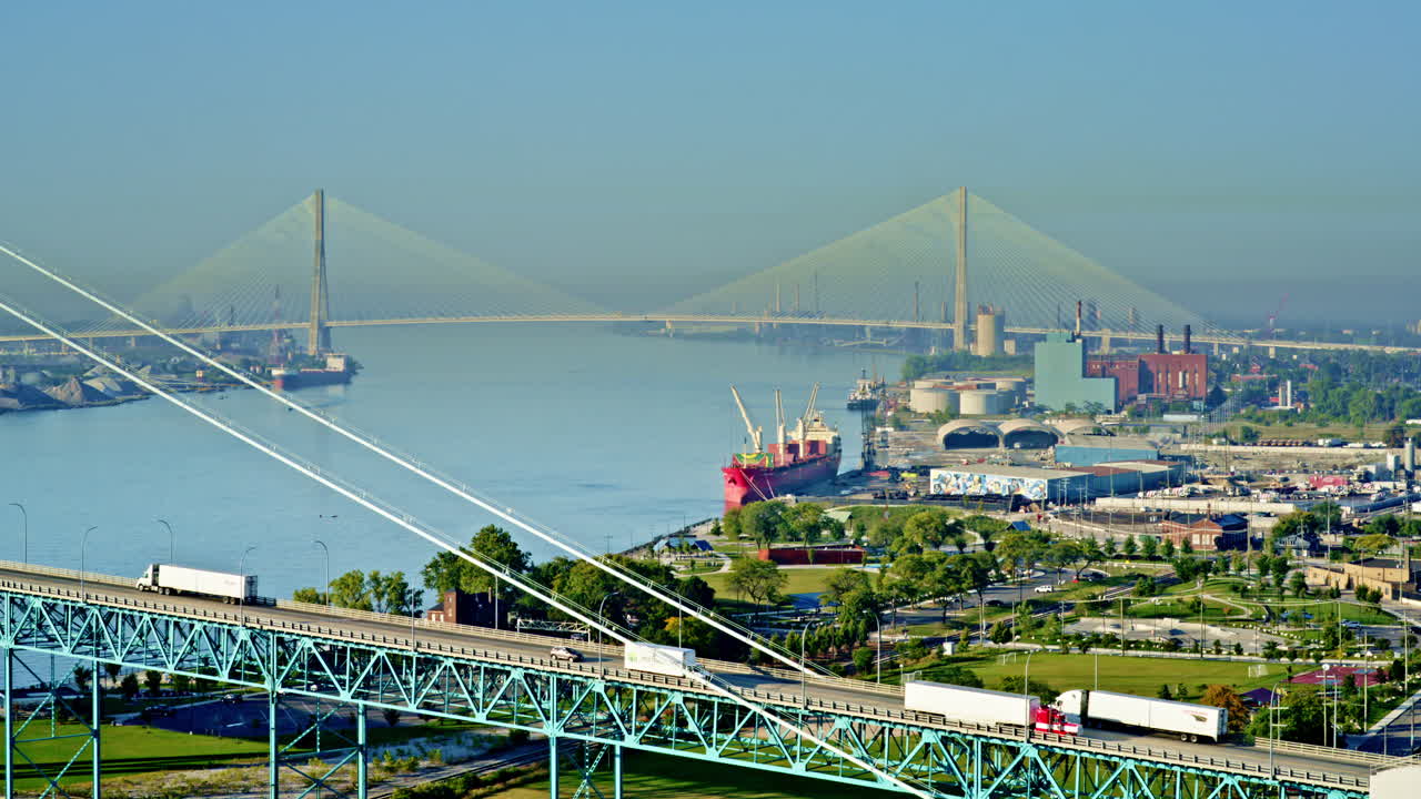 Smooth cinematic pass over the Detroit River, with a freighter and skyline adding depth to the shot