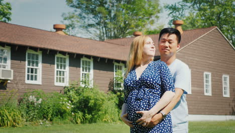 Happy-Young-Family-Near-Their-New-Home-Pregnant-Woman-And-Asian-Man