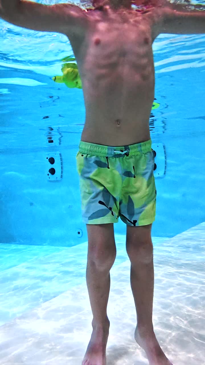 niño nadando bajo el agua en la piscina