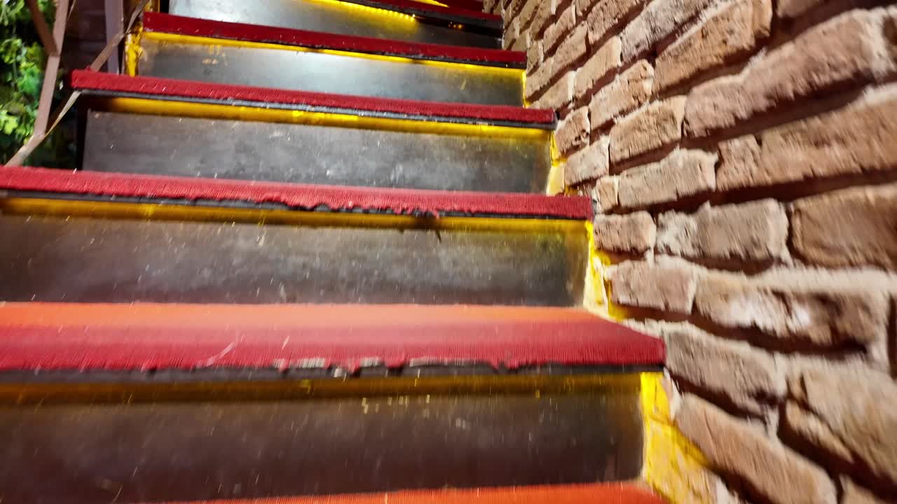 Illuminated Spiral Staircase with Red Carpet and Decorative Vases