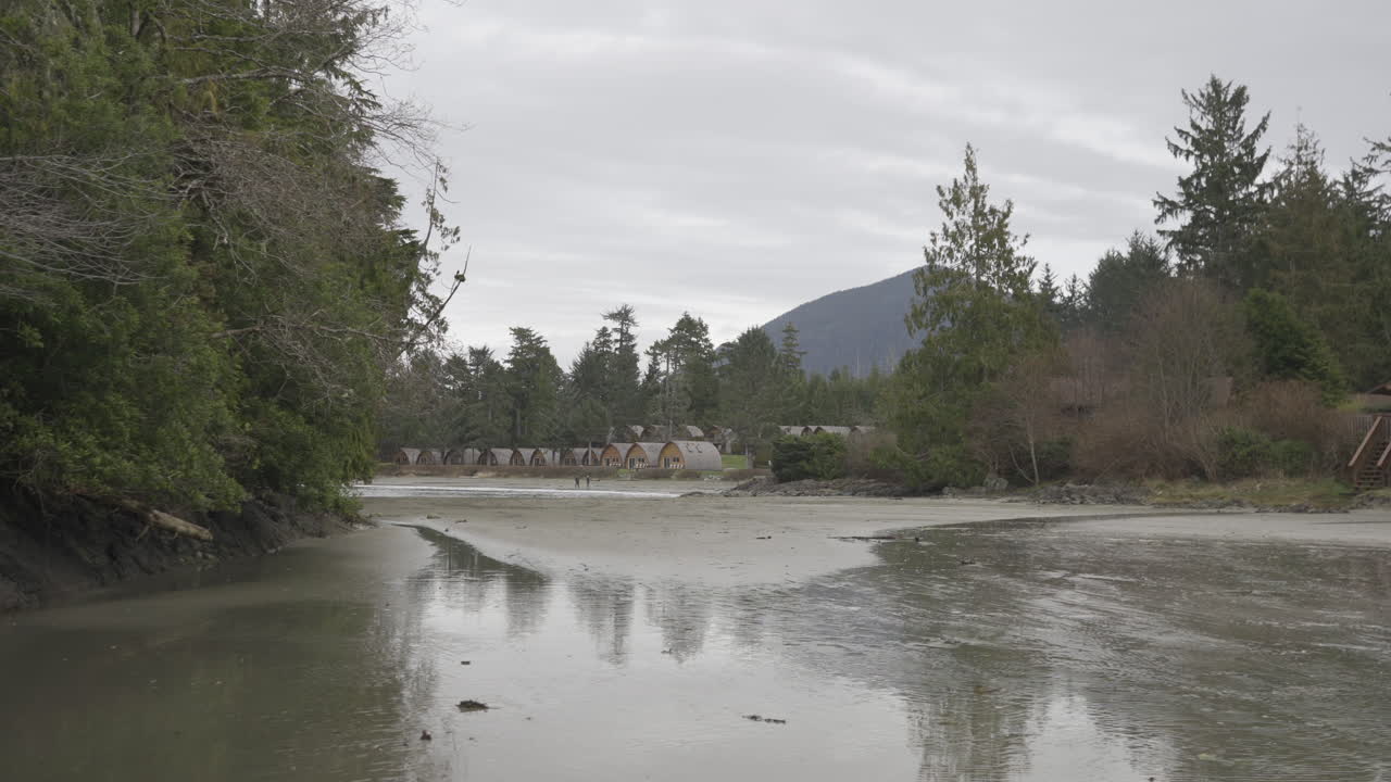 캐나다 브리티시 컬럼비아 토피노의 해변의 슬라이더, 배경에는 해변 전망의 오두막이 있습니다.