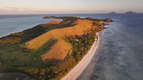 mana island bathed in golden light, during romantic sunset. long sandy beach, tropical landscape