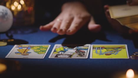 primer plano de una mujer dando una lectura de tarot en la mesa a la luz de las velas 13