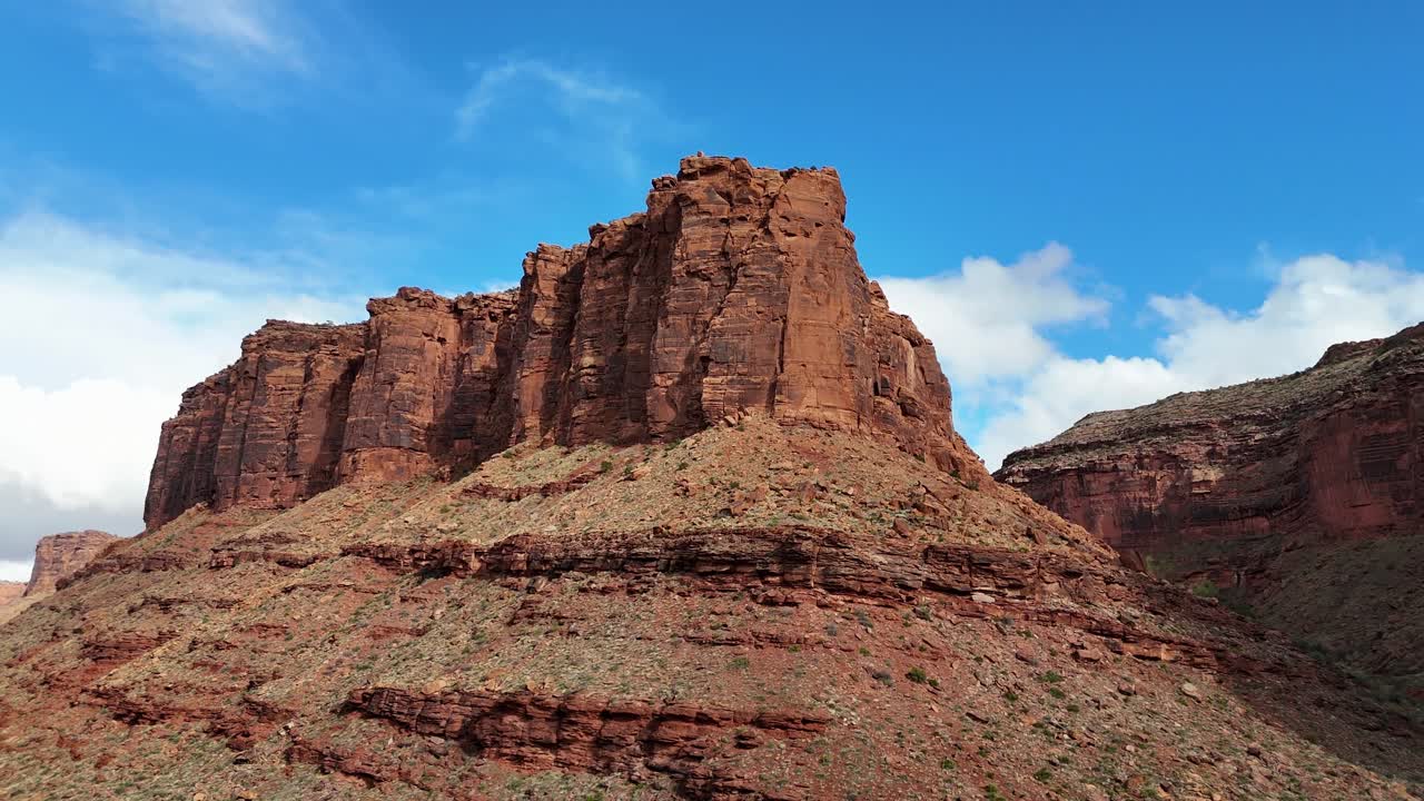 Drone Panning around Red Butte in the Desert with clouds and blue sky in background. Moab, Utah early spring