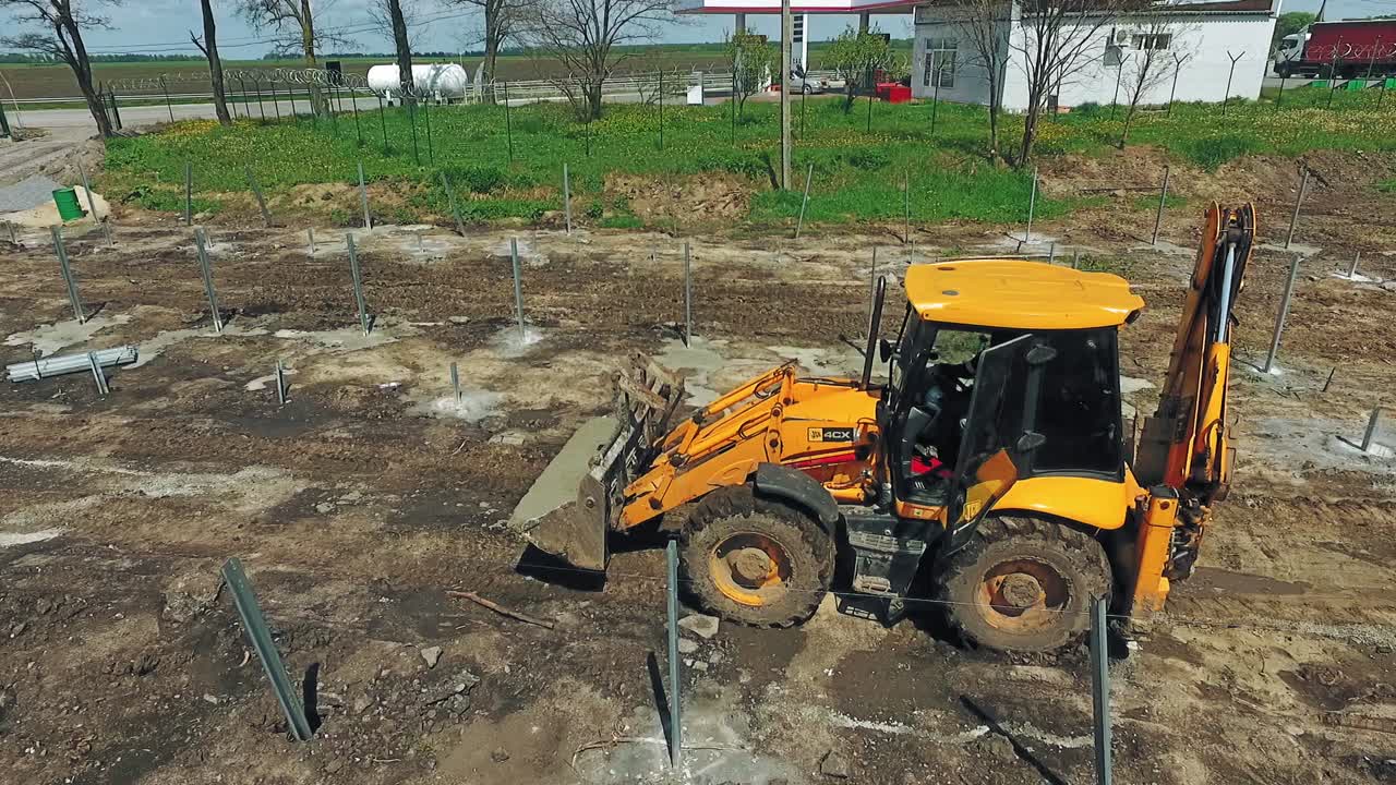 Construction site in progress. Aerial drone view of tractor working at construction site