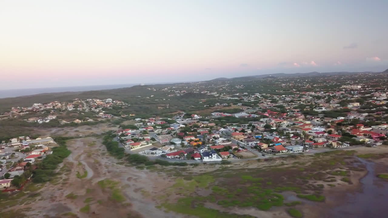 casas en noord, aruba durante la puesta de sol con el mar caribe de fondo