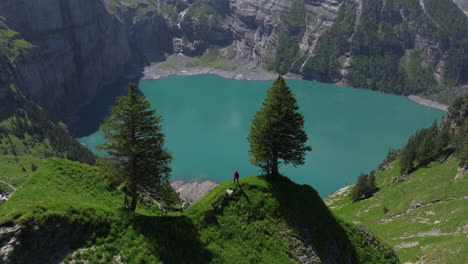 Vista-Aérea-Del-Lago-Oeschinen-Con-Imponentes-Montañas-Rocosas-En-El-Oberland-Bernés,-Suiza