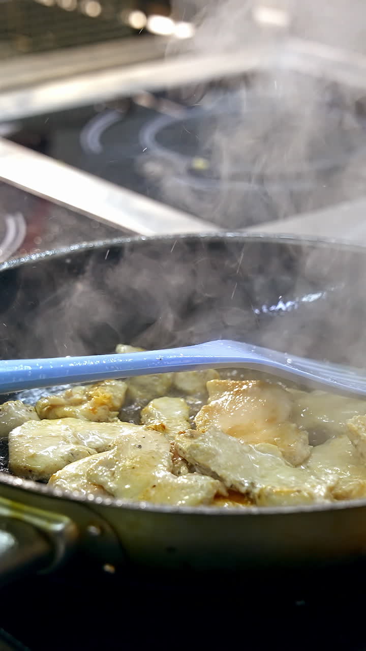 Frying food on iron pan. Chef cooking food in large pan at restaurant. Vertical video