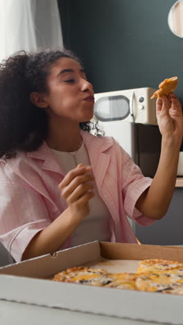 young woman enjoying pizza at home
