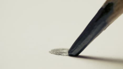 graphite pencil draws a dot circle line on a white background paper, macro shot