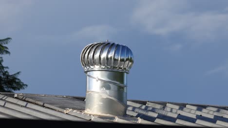 rotating vent on a shingled rooftop against sky