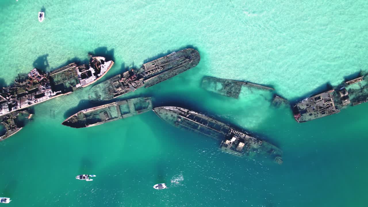 Drone footage showcasing Tangalooma Wrecks and boats in crystal-clear turquoise waters, Moreton Island.
