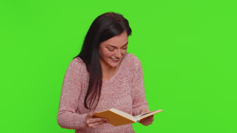 mujer feliz leyendo un libro frente a una pantalla verde