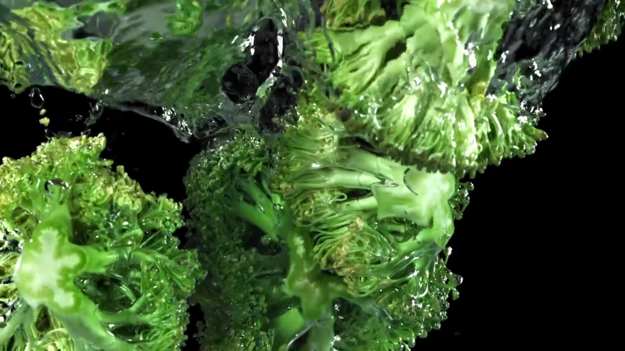 Cimette di broccoli fresche che schizzano nell'acqua al rallentatore