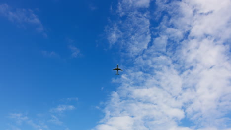 airplane flying high above the clouds in a clear blue sky