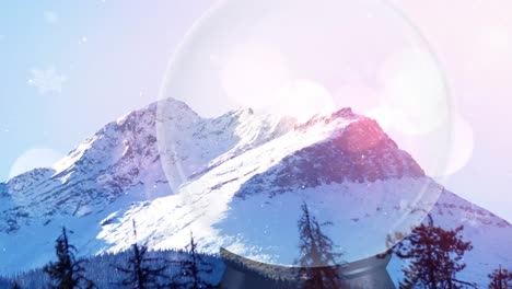 animation of snow glass ball over winter mountain landscape