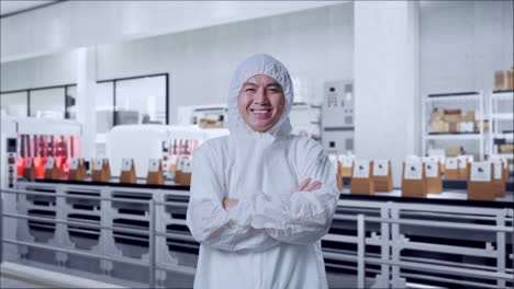 asian male scientist crossing his arms and smiling with conveyor for packaging coffee beans in bags at coffee factory