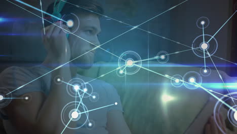 Animation of networks of connections with icons over man using tablet