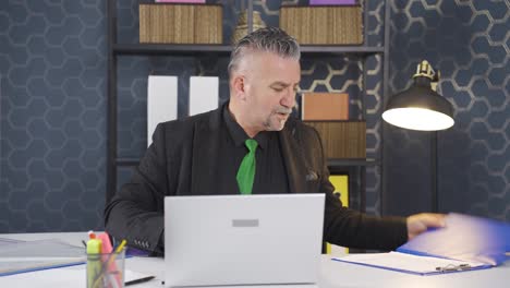 Businessman-looking-for-documents-at-the-table.