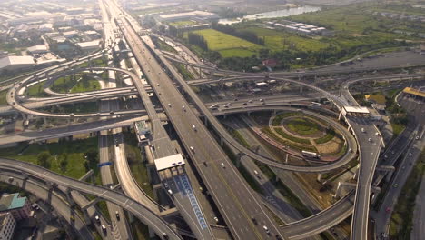 aerial view of highway road interchange with busy urban traffic speeding on road