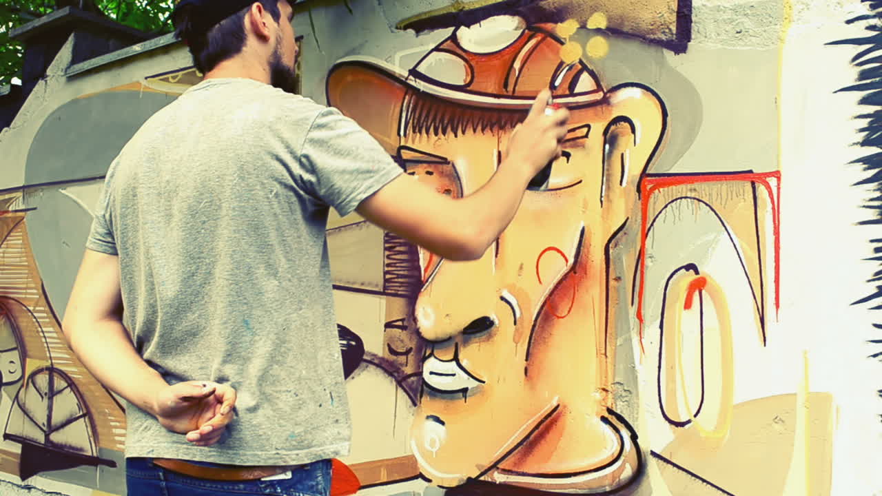 L'artista disegna graffiti su una recinzione. Graffiti su una recinzione.