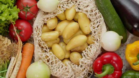 vegetables in reusable net bags on white scratched background, top view. zero waste and eco