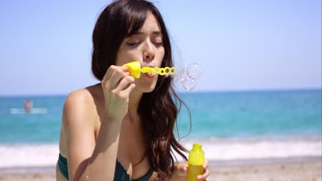 bastante, mujer joven, soplar burbujas, en, un, playa
