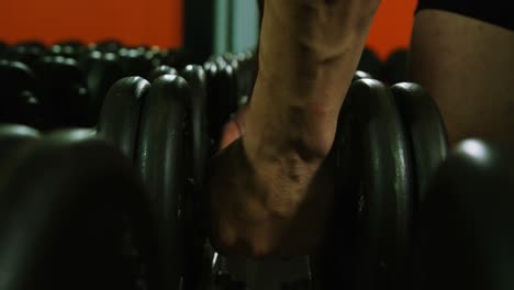 hands of man holding dumbbell
