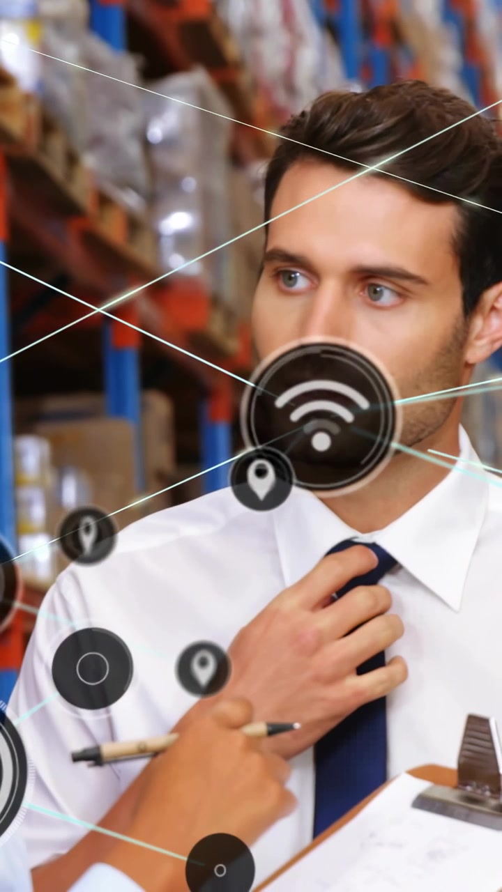Video verticale: Donna che indica un blocco note con icone HUD che si illuminano, uomo che sistema e coordina il magazzino