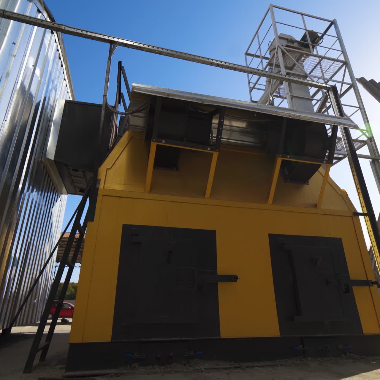 Modern constructions on a factory outdoors. Industrial equipment near grain elevators. Exterior of a modern plant for agribusiness