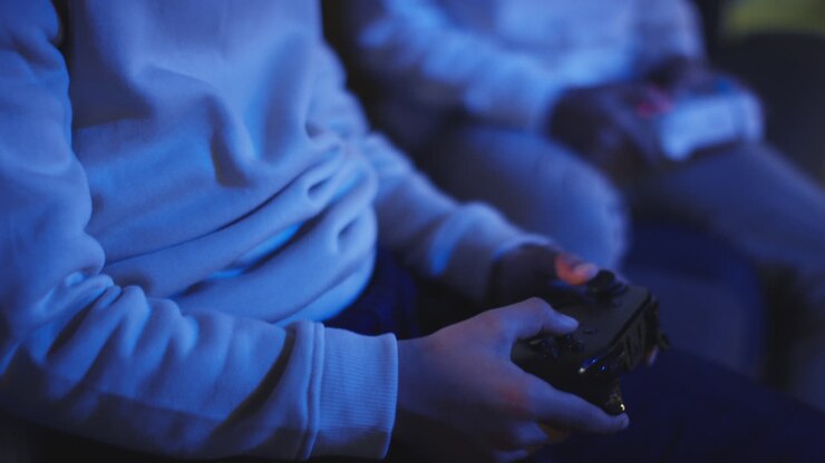 Close Up Of Two Young Boys At Home Playing With Computer Games Console On TV Holding Controllers Late At Night 11