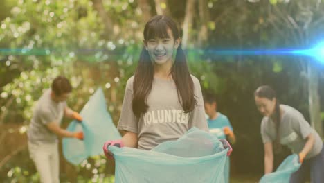 video of lights over happy asian girl and family picking up rubbish in countryside