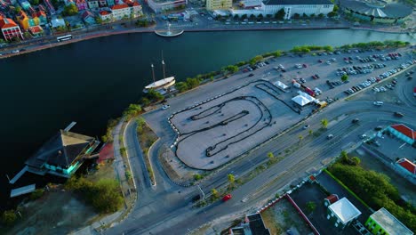 Aerial-panoramic-view-of-go-kart-racing-along-canal-river-in-willemstad-curacao