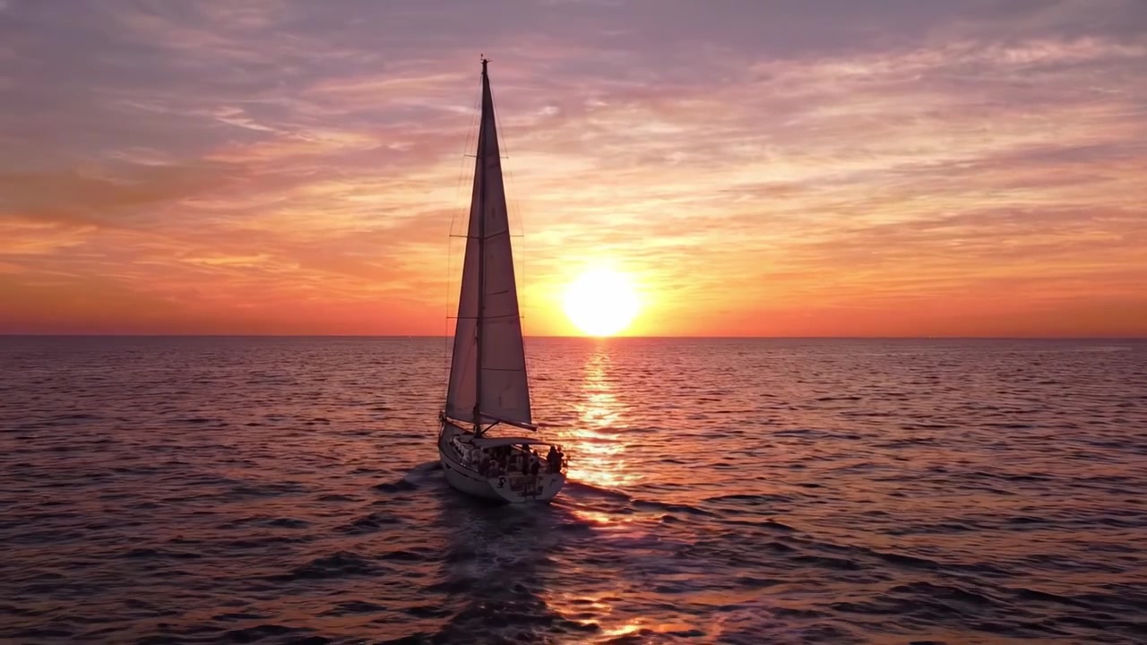 Uma Experiência Serena de Navegação ao Pôr do Sol: Vistas Cativantes de um Veleiro Deslizando por Águas Tranquilas Sob um Céu Majestoso Laranja e Rosa