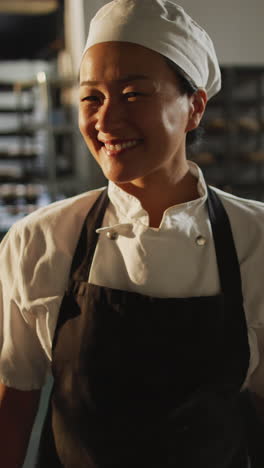 video vertical del retrato de una panadera asiática feliz en una panadería