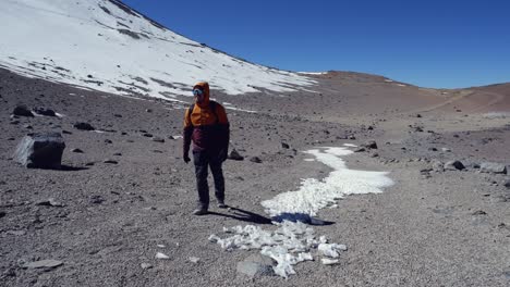 Männlicher-Wanderer-Geht-In-Abgelegener,-Schneebedeckter-Berglandschaft-Auf-Die-Kamera-Zu