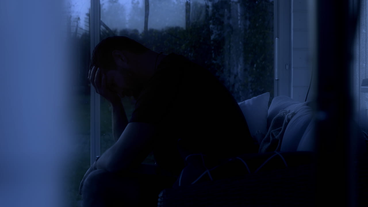 Close up of man with insomnia in dark room. Static