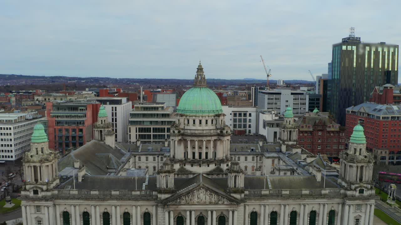 Dynamic drone pullback from Belfast City Hall dome revealing iconic building's grand architecture