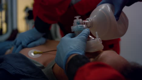 paramedics hands providing first aid help of man with cardiac respiratory mask