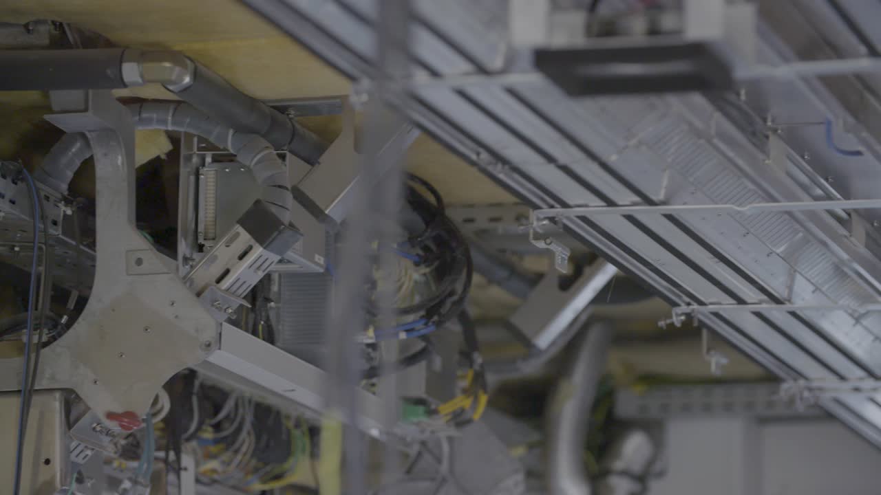 Close-up of a complex system of electrical wiring and cables captured in a documentary-style handheld shot, everything in focus