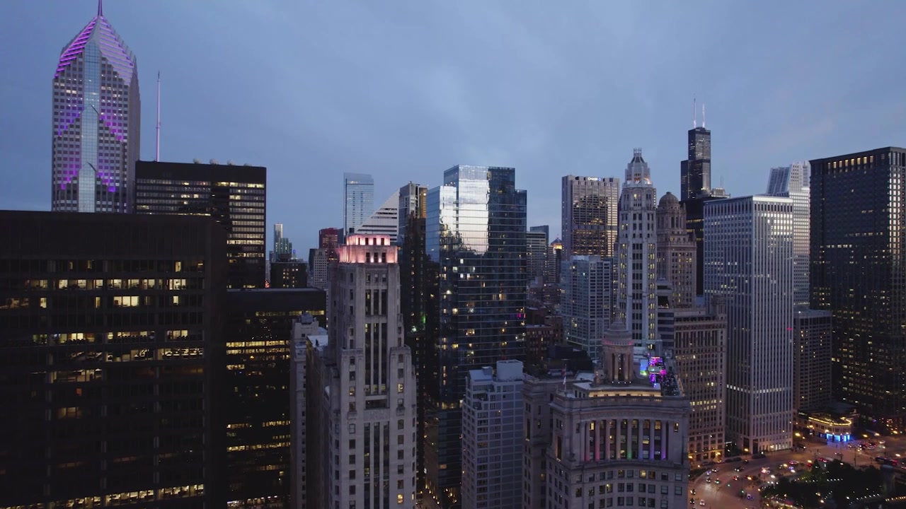 Vista aérea de drone sobre o centro de Chicago na hora azul, apresentando a Willis Tower, arranha-céus iluminados, arquitetura histórica e ruas da cidade brilhantes