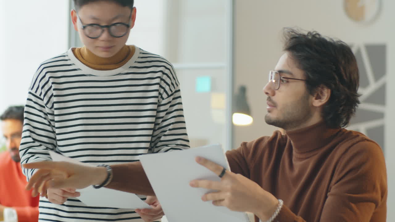 Asian Woman and Middle Eastern Man Working Together in Office