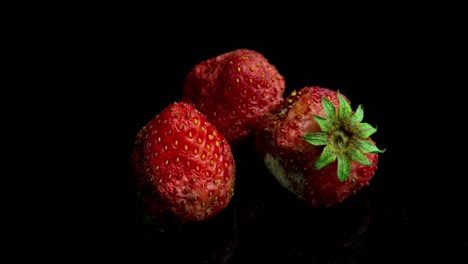 strawberry rots on a black background, time lapse, macro photography