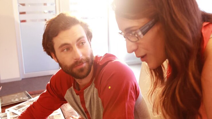 Male and female graphic designers interacting while working