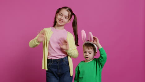 joyful little kids waving in front of camera during easter holiday