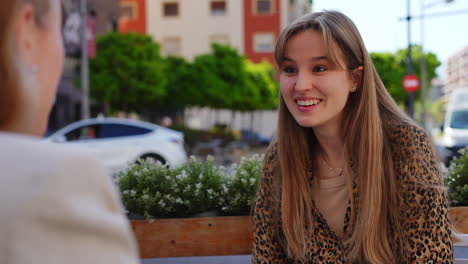 two women talking outdoors at a cafe
