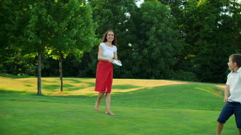 Parents-and-children-playing-frisbee-in-meadow.-Family-throwing-frisbee-disc