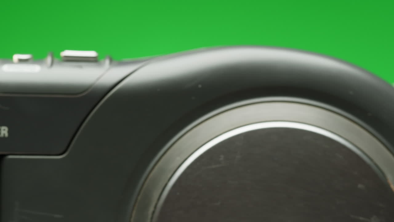 Vintage video-camera with disk inside rotating on green background close-up. Using portable camcorder to shooting videos