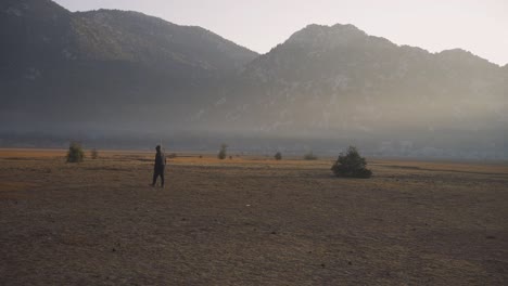 Toma-En-Cámara-Lenta-De-Un-Hombre-Caminando-Por-El-Valle-En-La-Cordillera-Ibradi-Akseki