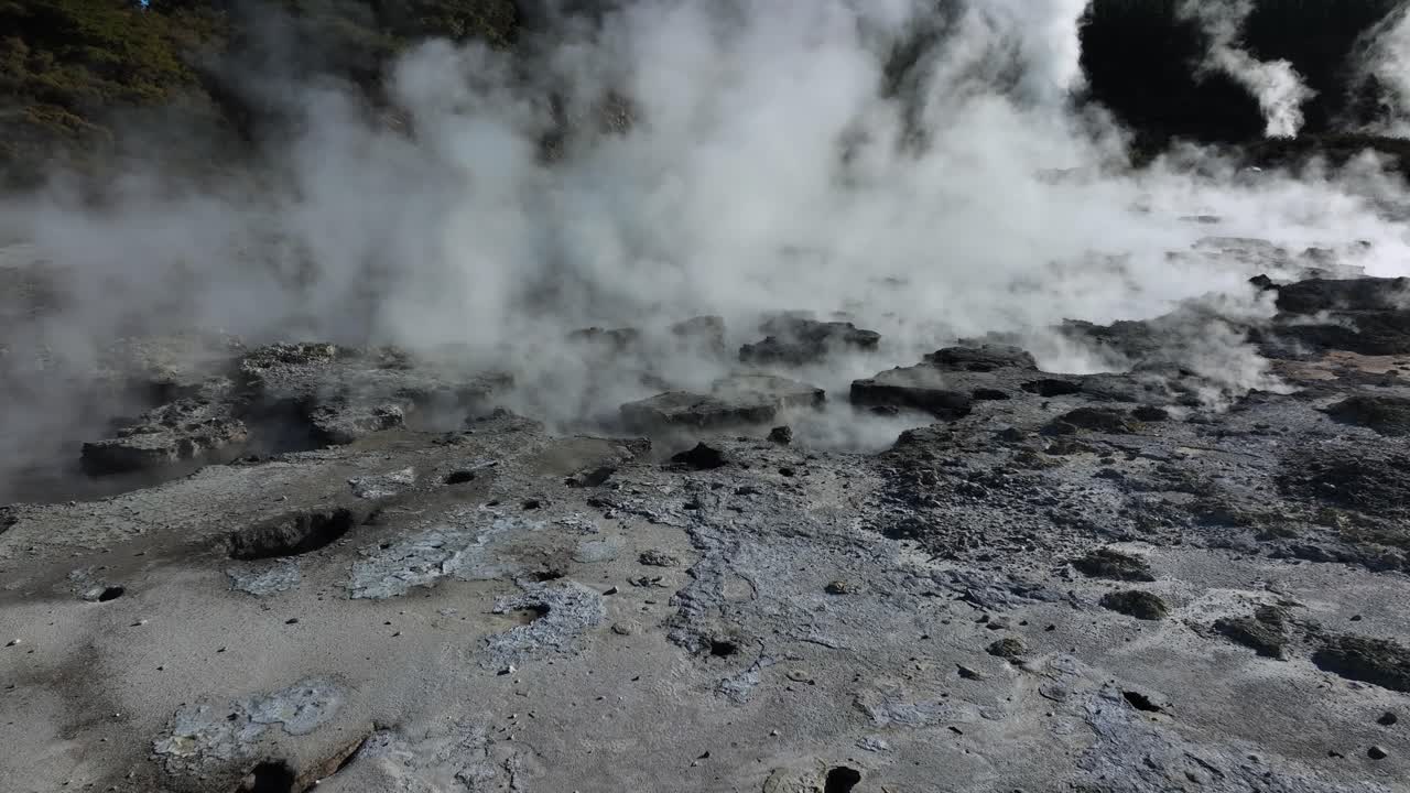 Extreme bubbling mud pools, Drone slowly flying over geothermal landscape. Trees, steam, bubbling mud and steam. Alien Landscape. Sci-fi. Global Warming